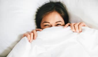 Smiling Female Covering Face With Blanket