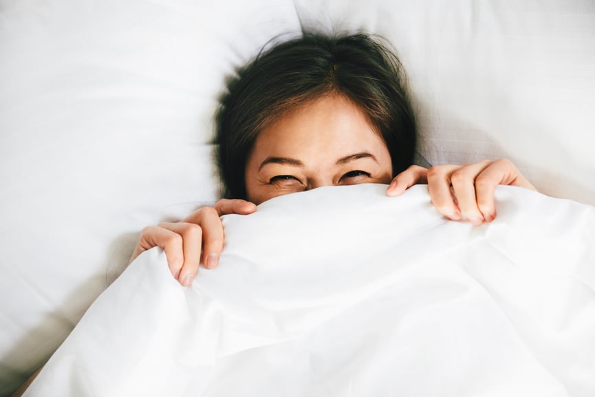 Smiling Female Covering Face With Blanket